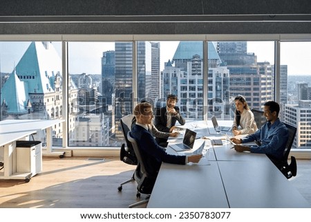 Busy young professional international board executives, diverse team people group discussing financial results managing company project working together in modern meeting room. Royalty-Free Stock Photo #2350783077