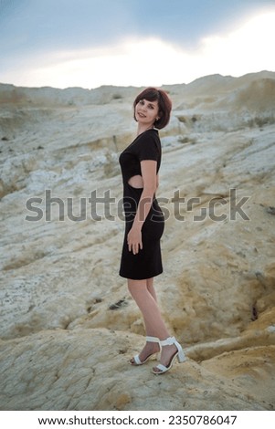 A woman is photographed in the desert before a thunderstorm.