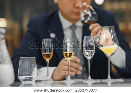 Beginner wine waiter sniffs alcoholic drink during blind tasting. Sommelier school, international certification. Royalty-Free Stock Photo #2350798377