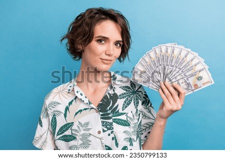 Photo of positive cheerful lady wear print shirt rising money fan smiling isolated blue color background