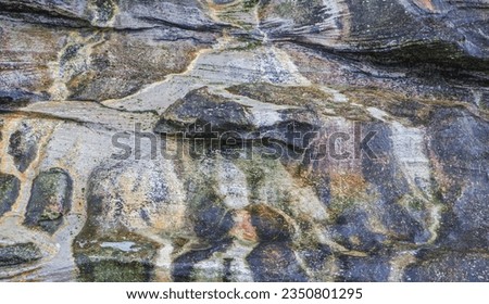 Colorful patterns formed, by water flow in rock, alcove; Saunders Island, Falkland Islands