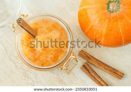 Homemade pumpkin face mask in a glass jar. Natural autumn beauty treatment and spa recipe. Top view, copy space. 