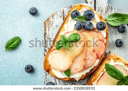 Homemade summer toast with cream cheese, honey, peaches and blueberries. Concept healthy and balanced eating. place for text, top view.