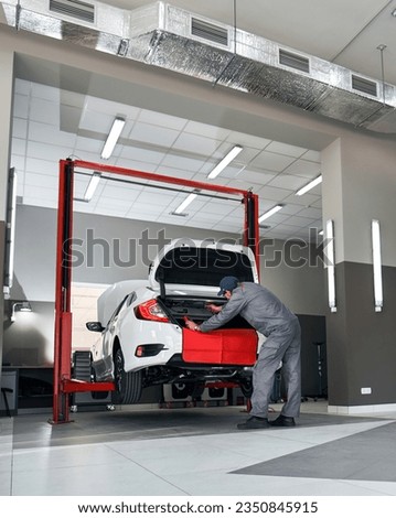 Expert Car Repair. Skilled Mechanic Conducts Maintenance in Service Panorama. Mechanic repairing a car. Royalty-Free Stock Photo #2350845915