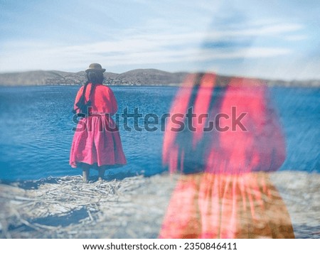 A colorful silhouette of an indigenous woman (Cholita in Quechua), standing and watching the horizon of Titicaca Lake on the Uros islands, a famous tourist spot. Creative double-exposure photography Royalty-Free Stock Photo #2350846411