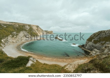 A crescent-shaped sea cove surrounded by a rocky coastline and beach on the Dorset coast in southern England. Located next Durdle Door. Man O' War Beach. High quality photo