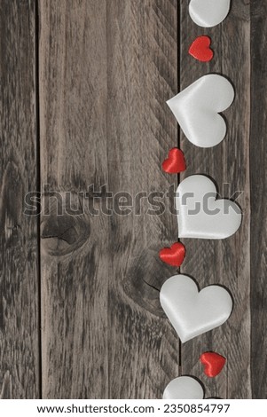 Love concept. White and red hearts on wooden background