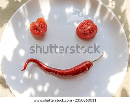Composition on a plate in the shape of a funny face. Pepper, tomatoes, sliced serving