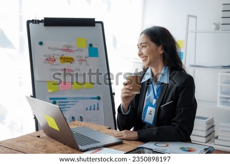 Asian Businesswoman Using laptop computer and working at office with calculator document on desk