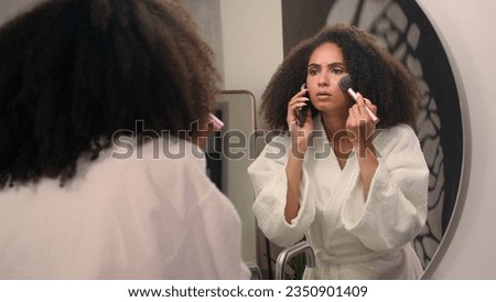 Beautiful African American woman late to dating girl in bathrobe at home mirror reflection apply powder for face make up cosmetics answer call angry mad screaming in mobile phone conflict quarrel yell Royalty-Free Stock Photo #2350901409