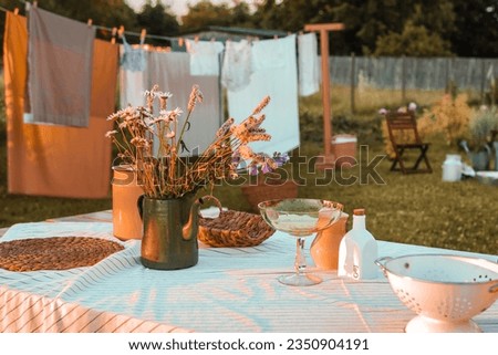 A covered wooden table in the courtyard of a country house. Country life, life in the country Royalty-Free Stock Photo #2350904191