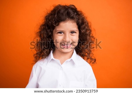 Photo of cheerful adorable clever schoolkid beaming smile good mood isolated on vibrant orange color background