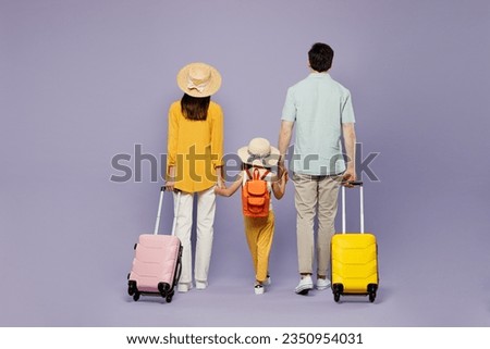 Back view traveler parents mom dad with child girl wear casual clothes with bags isolated on plain purple background. Tourist travel abroad in free time rest getaway. Air flight trip journey concept Royalty-Free Stock Photo #2350954031