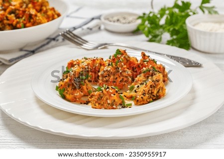 bang bang broccoli bites, crispy baked broccoli florets tossed with mayo sriracha sauce on white plate on white wooden table, horizontal view from above, close-up Royalty-Free Stock Photo #2350955917