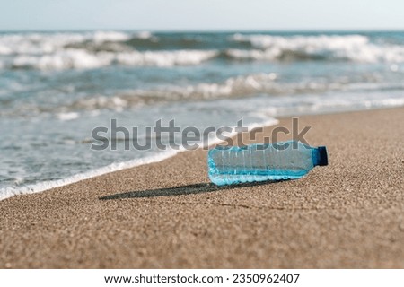 a plastic bottle lies on the sand on the seashore on the beach. 
