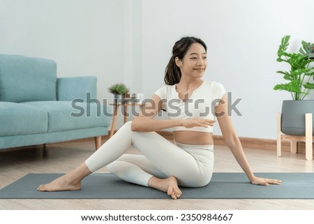 Slim woman practicing yoga on room of her condo or home. Asian woman doing exercises in morning. balance, meditation, relaxation, calm, good health, happy, relax, healthy lifestyle, diet, slim Royalty-Free Stock Photo #2350984667