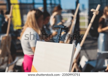 Process of drawing, group class of talented students with painting easels and canvases during lesson of watercolour painting outdoors, drawing class for adult artists in art school 