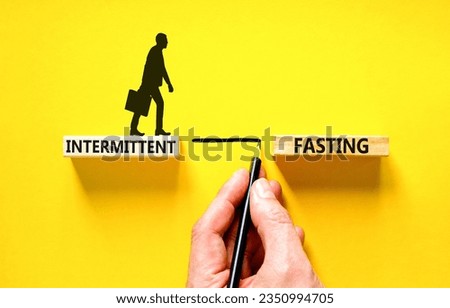 Intermittent fasting symbol. Concept words Intermittent fasting on beautiful wooden block. Beautiful yellow table yellow background. Healthy lifestyle intermittent fasting concept. Copy space.