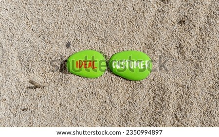 Ideal customer symbol. Concept words Ideal customer on beautiful green stone. Beautiful sand beach background. Business ideal customer concept. Copy space.
