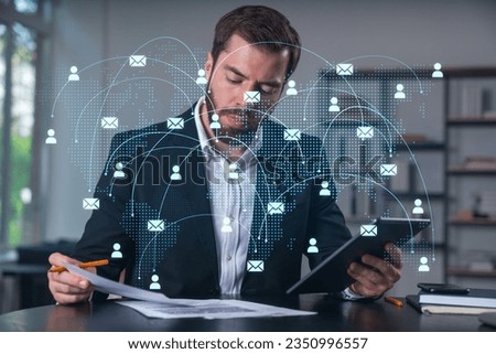 Considered businessman in formal wear signing contract holding tablet device at office room with papers. Concept of successful business deal, agreement, partnership, documents. Social network icons.