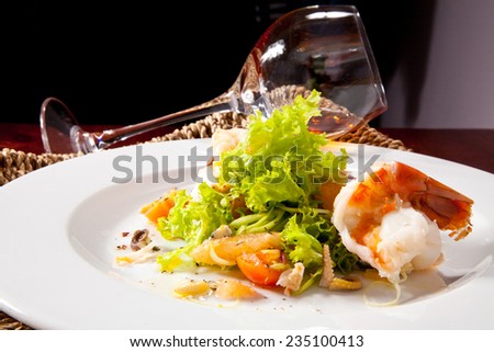 Shrimp with Octopus in the Leaves of Green Salad with Cherry Tomatoes and Fresh Herbs. Photo, picture