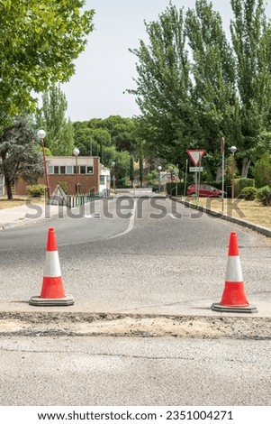 Traffic cones in front of a ditch to signal asphalt conditioning works