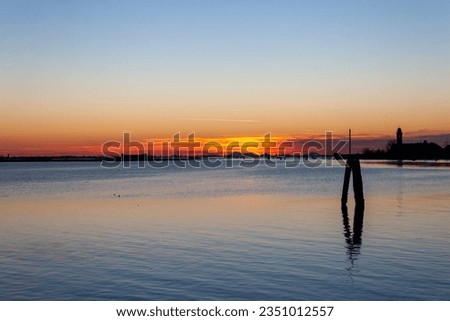 Burano, Italy - February 12, 2023: Sunset over the Venice lagoon seen from Burano island. Royalty-Free Stock Photo #2351012557