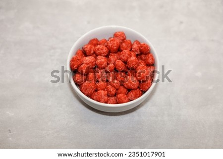 A white small bowl with traditional Mexican cacahuates garapinados (caramelized peanuts).
