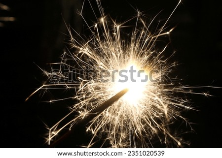 Sparkler igniting and sending off light at night. Taken with slower shutter speed to allow picture.