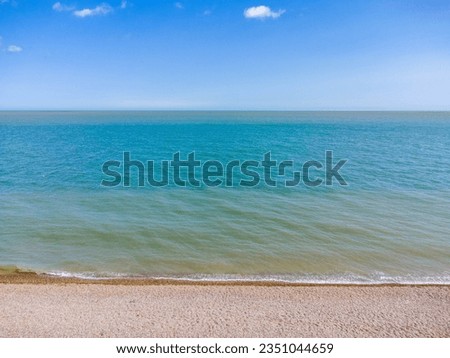 Captivating aerial view: endless beach meeting the sea, merging seamlessly with the horizon. A tranquil canvas of nature's vast beauty