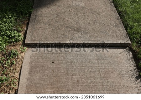 uneven concrete sidewalk with shadow Royalty-Free Stock Photo #2351061699
