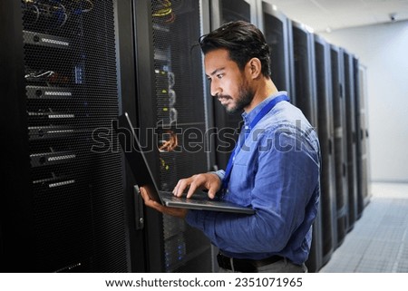 Programming, data center and a man with a laptop for maintenance, cyber security and internet check. Coding, email and an Asian programmer typing on a computer for network or server analytics Royalty-Free Stock Photo #2351071965