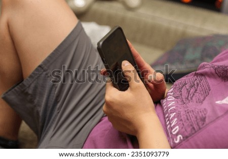 Hand holding phone embodies modern connection, communication, and technology's grasp on daily life
