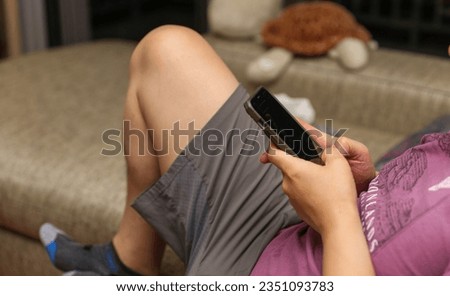 Hand holding phone embodies modern connection, communication, and technology's grasp on daily life