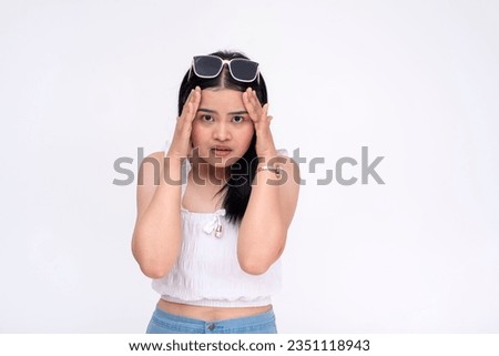 An unnerved young asian woman having a panic attack. Looking at camera with a worried expression. Isolated on a white background. Royalty-Free Stock Photo #2351118943