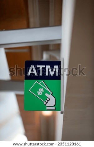 ATM sign hanging on a wall in a modern building