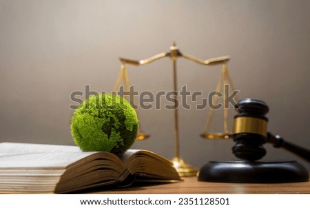 the green world is in the book There is a judging hammer behind it. The concept of global natural law and environmental judgment Royalty-Free Stock Photo #2351128501