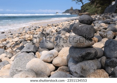 Stone balance on beach with blurred background, concept of balance and harmony