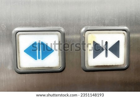 a photography of two buttons on a metal surface with a blue arrow and a blue arrow.