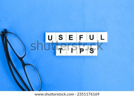 glasses and letters of the alphabet with the words useful tips. the concept of tips and tricks
