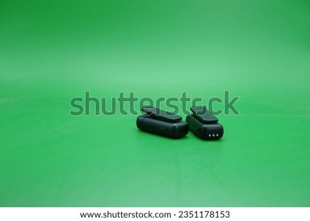 a pair of wireless mics over a green background. wireless mic that is usually used by content creators.