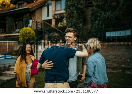 	
The male host welcomes and hugs friends who are coming to his house.