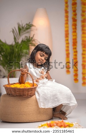 Happy Onam greeting image, Indian young girlwearing traditional dress and making Onam Pookalam, Diwali and rangoli concept image