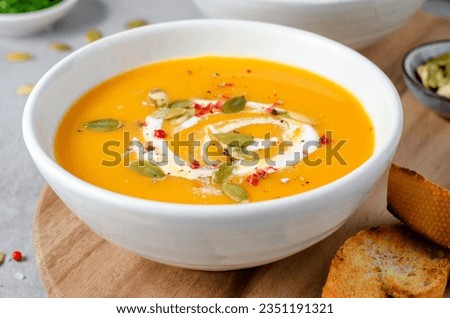 Pumpkin Soup, Tasty Homemade Pumpkin, Sweet Potato or Carrot Soup in a Bowl on Bright Background
