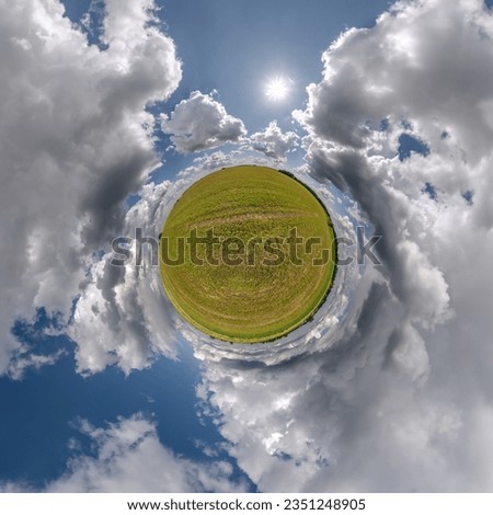 green tiny planet in blue sky with beautiful clouds with transformation of spherical panorama 360 degrees. Curvature of space.