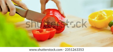 Closeup on housewife cutting red bell pepper on cutting board Royalty-Free Stock Photo #2351263353