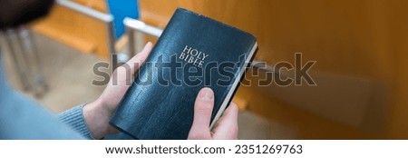 young man hand holding Holy Bible
