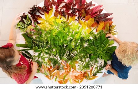 Kids pick colorful autumn leaves for school art project. Boy and girl making picture gluing fall leaf in rainbow color. Crafts for young children. Preschool and kindergarten arts homework.