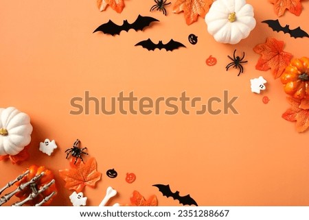 Happy Halloween concept. Scary bats silhouettes, pumpkins, spiders, fallen leaves on orange background.