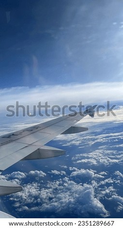 Portrait picture breathtaking view of the airplane wings with blue sky background on airplane during flight
